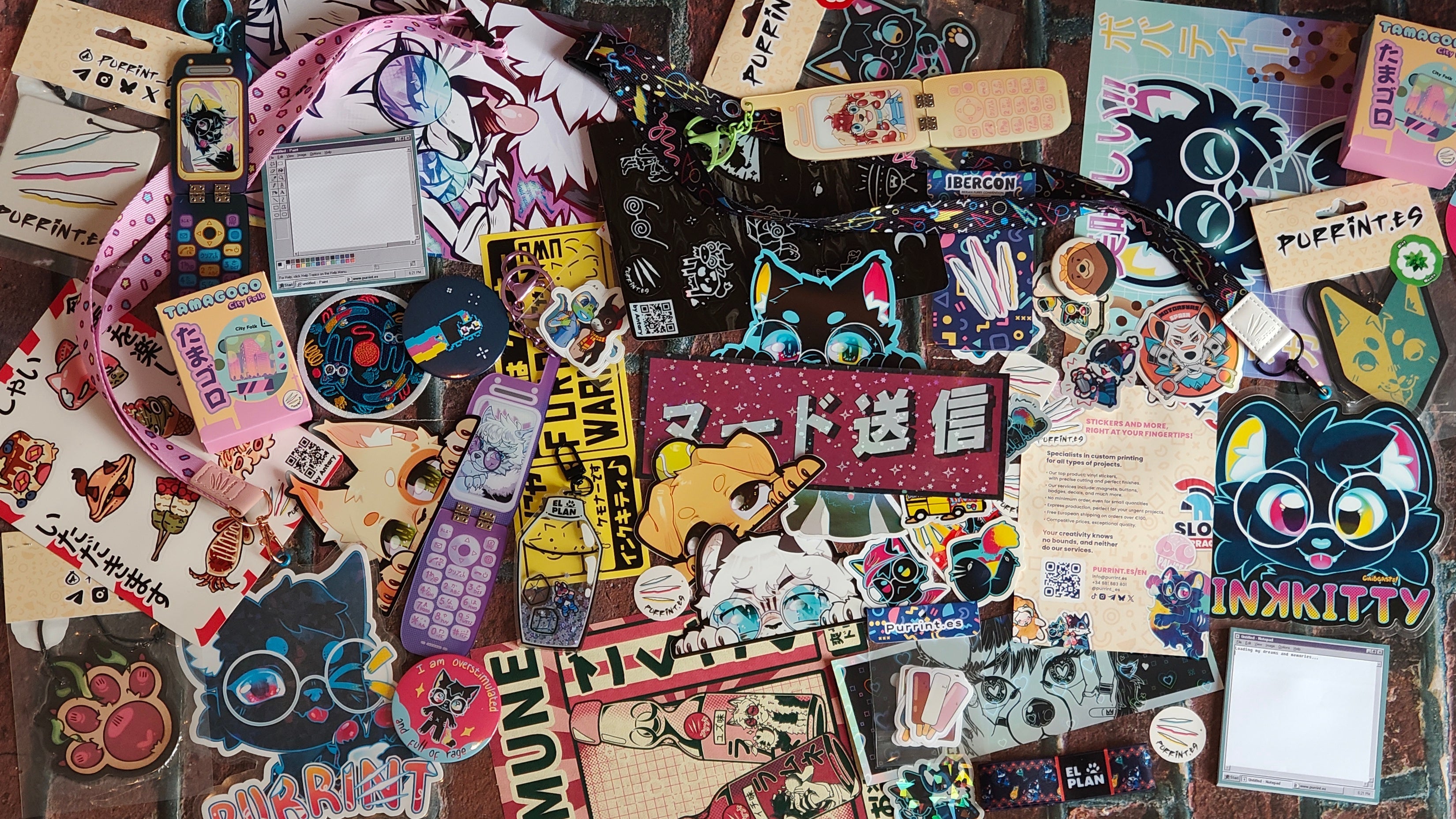 Collection of various stickers and pins on a textured surface